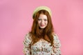 Young smiling woman with red hairstyle looking to camera. Portrait of cute beautiful girl on pink studio wall background Royalty Free Stock Photo