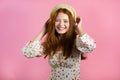 Young smiling woman with red hairstyle looking to camera. Portrait of cute beautiful girl on pink studio wall background Royalty Free Stock Photo