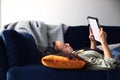 Young Smiling Woman Relaxing At Home Lying On Sofa Reading Book On Digital Tablet Royalty Free Stock Photo