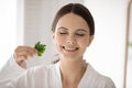 Young smiling woman rubbing parsley in fingers enjoying fresh aroma Royalty Free Stock Photo