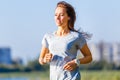 Young smiling woman running in park in the morning Royalty Free Stock Photo