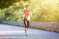 Young smiling woman running in park in the morning Royalty Free Stock Photo