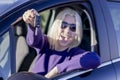 Happy young smiling woman seated in her new car showing the car key. Focus on the key Royalty Free Stock Photo