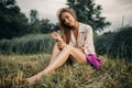 Young smiling woman sits on bevelled meadow. Royalty Free Stock Photo