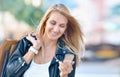 Young smiling woman with shoping bags look at cellular telephone