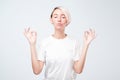 Young smiling woman with short colored hairstyle meditating, holding her hands in yoga gesture, feeling calm Royalty Free Stock Photo