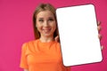 Young smiling woman showing digital tablet with blank screen against pink background Royalty Free Stock Photo