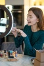 Young smiling woman shpowing new eyeshadows to onine audience