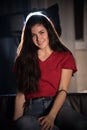 Young smiling woman sitting on a couch. Looking in the camera. Posing Royalty Free Stock Photo