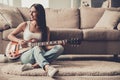 Young Smiling Woman Sitting and Playing Guitar. Royalty Free Stock Photo