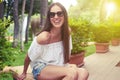 Young smiling woman sitting in sunny yard Royalty Free Stock Photo