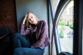 Young woman sitting on window sill in cafe Royalty Free Stock Photo