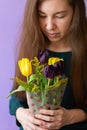 Young smiling woman with spring tulip flowrs in wrapping paper.Long blond haired young woman with bouquet