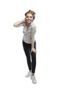 Young smiling woman is standing. A beautiful blonde in black leggings, a gray T-shirt and white sneakers. Positiveness, happiness Royalty Free Stock Photo