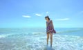 Young smiling woman standing in sea waves and holding her dress Royalty Free Stock Photo