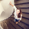 Young smiling woman stepping down at curved stairs