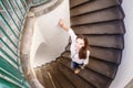 Young smiling woman stepping down at curved stairs
