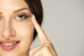 Young smiling woman tightening her face skin with her fingers Royalty Free Stock Photo