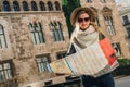 Young woman tourist stands on street of ancient European city and holds map. In background is beautiful building. Royalty Free Stock Photo