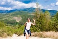 Young smiling woman tourist showing victory sign on the top of the mountain. Hiking concept. Vacation in the mountains Royalty Free Stock Photo