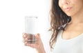 Young smiling woman in white clothes holds a glass of water in her hand. White background. Copy Space Royalty Free Stock Photo