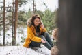 Young smiling woman in yellow jacket with big kind white dog Labrador walking in the winter forest Royalty Free Stock Photo