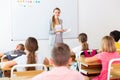 Young attractive female teacher giving lesson to children Royalty Free Stock Photo