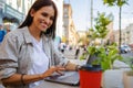 Beautiful entrepreneur using laptop during lunch in outdoor cafe, elegant businesswoman holding coffee cup working in city street. Royalty Free Stock Photo