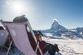 Young snowboarder cheering with a beer after skiing day in a bar or a cafe at the Zermatt ski resort