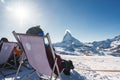 Young snowboarder cheering with a beer after skiing day in a bar or a cafe at the Zermatt ski resort