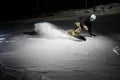 Young snowboarder riding down the snowy mountain slope at night Royalty Free Stock Photo