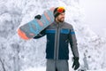 Snowboarder holding board on terrain