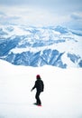 Young snowboarder ride downhill in scenic caucasus mountains in fast freeze motion steep downhill solo Royalty Free Stock Photo