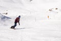 Young snowboarder sliding down snowy slope on mountain at winter resort