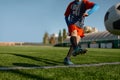 Young soccer goalie starting game kicking ball from white goal line