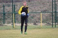 Young soccer goalkeeper holds the ball in his hands