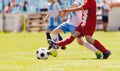 Young soccer players compete in a game. Two boys kicking football ball on tournament match Royalty Free Stock Photo