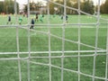 Young soccer team on playground viewed through net Royalty Free Stock Photo