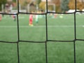 Young soccer team on playground viewed through net Royalty Free Stock Photo