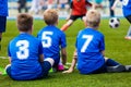 Young soccer team. Reserve players sitting together and watching