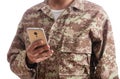 Young soldier holding a mobile phone standing on white background Royalty Free Stock Photo