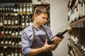 Young sommelier holding bottle of red wine in cellar Royalty Free Stock Photo