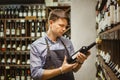 Young sommelier holding bottle of red wine in cellar Royalty Free Stock Photo