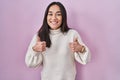 Young south asian woman standing over pink background success sign doing positive gesture with hand, thumbs up smiling and happy Royalty Free Stock Photo