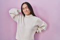 Young south asian woman standing over pink background suffering of neck ache injury, touching neck with hand, muscular pain Royalty Free Stock Photo