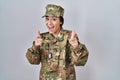 Young south asian woman wearing camouflage army uniform pointing fingers to camera with happy and funny face Royalty Free Stock Photo