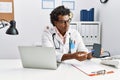 Young south east man wearing doctor uniform showing app medical smartphone at clinic