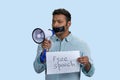 Young southasian man holding sheet of paper and megaphone. Royalty Free Stock Photo