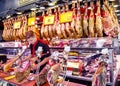 Young spanish dealer slicing iberico and serrano jamon