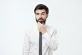 Young spanish guy wondering rubbing his chin. Royalty Free Stock Photo